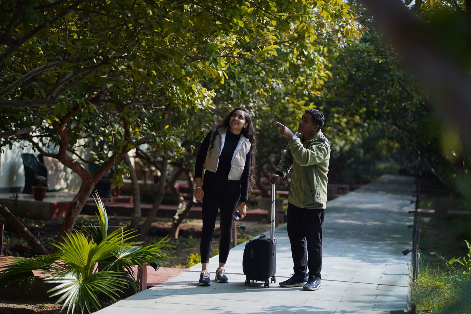 Resort staff welcoming a guest on a garden path