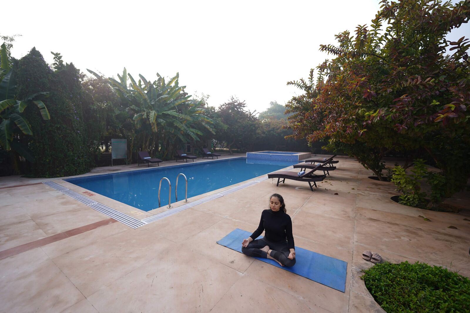 Guest meditating beside the resort pool