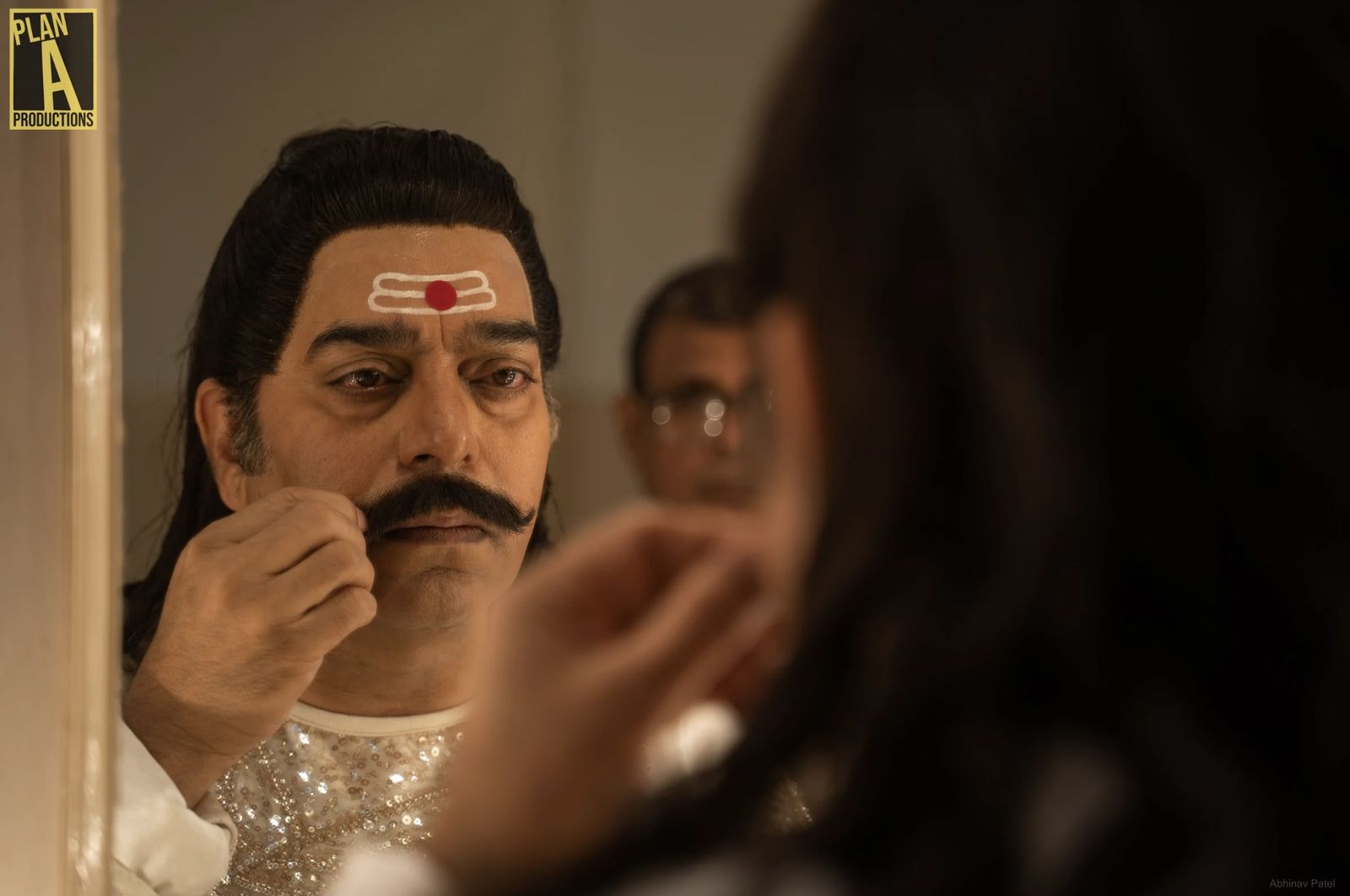 Makeup artist applying prosthetic makeup to an actor