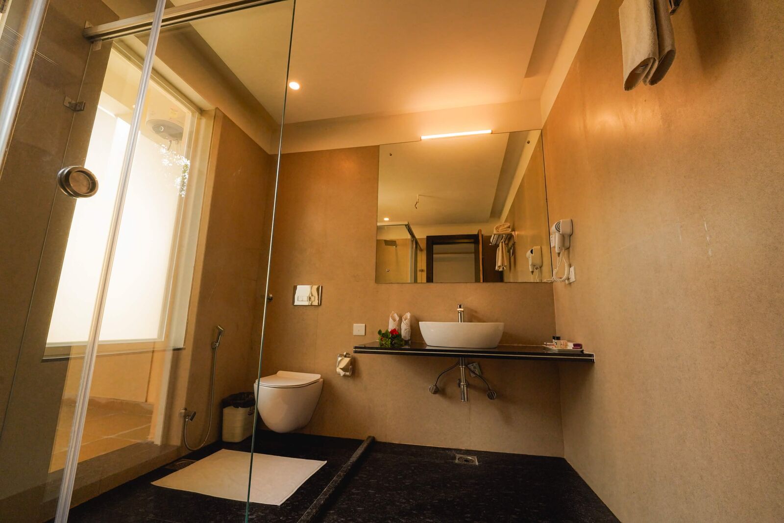 Resort bathroom with a glass shower and garden window