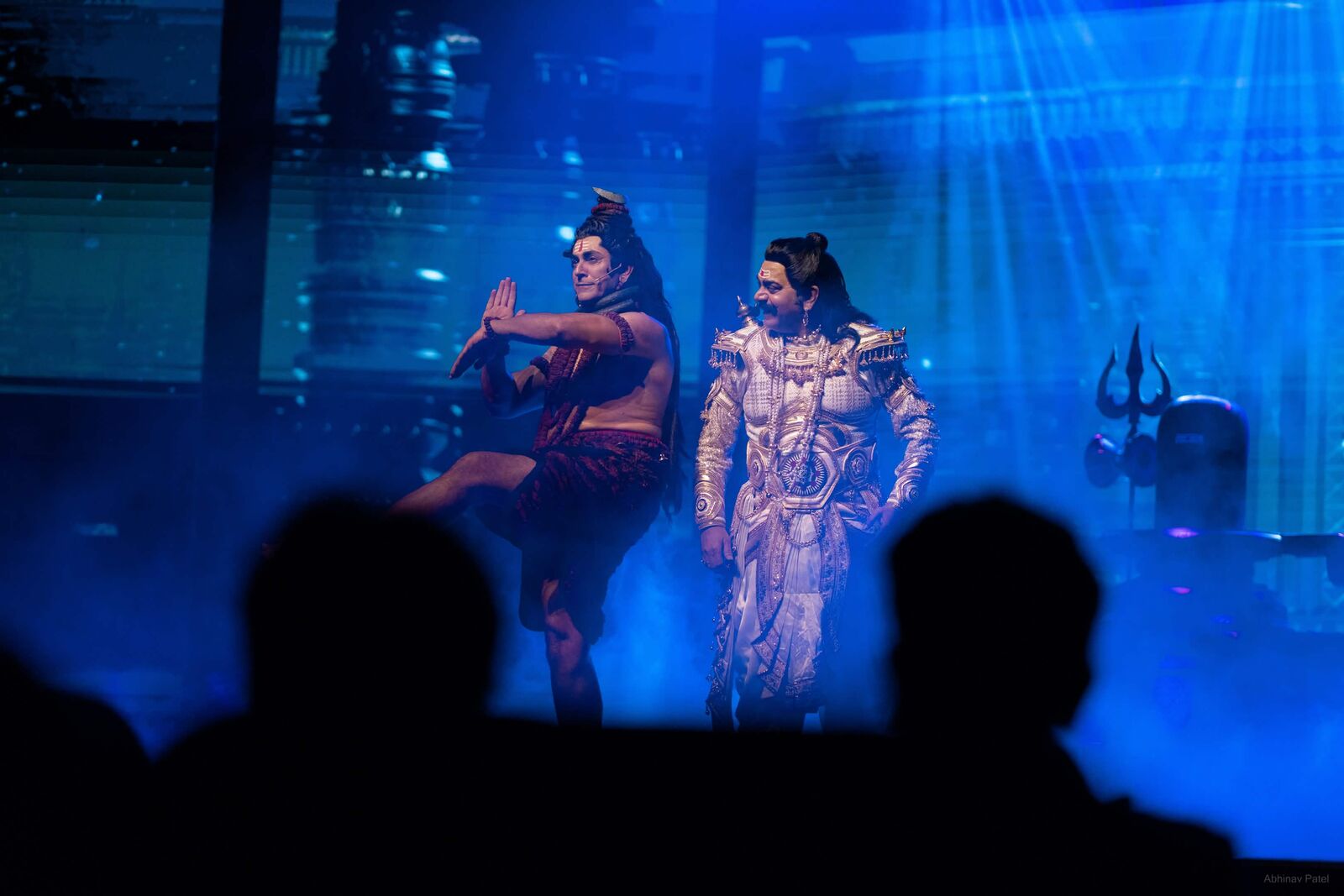 Shiva performer dancing beside a silver-costumed actor